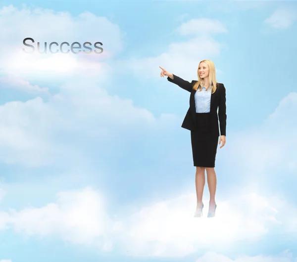 Businesswoman pointing at success word in the sky — Stock Photo, Image