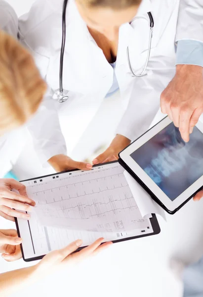 Ärztegruppe schaut sich Röntgenbild auf Tablet-PC an — Stockfoto