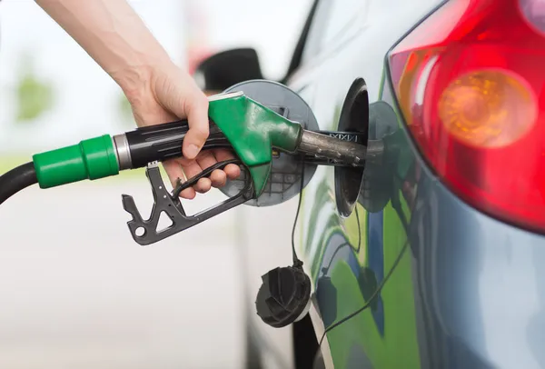 Homem bombeando gasolina combustível no carro no posto de gasolina — Fotografia de Stock