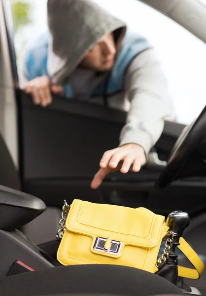 Thief stealing bag from the car — Stock Photo, Image