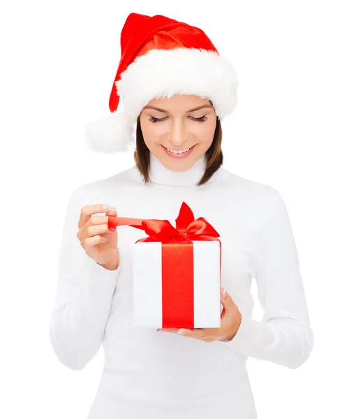 Donna sorridente in cappello Babbo Natale helper con confezione regalo — Foto Stock