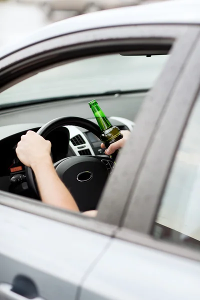 Мужчина пьет алкоголь за рулём автомобиля — стоковое фото