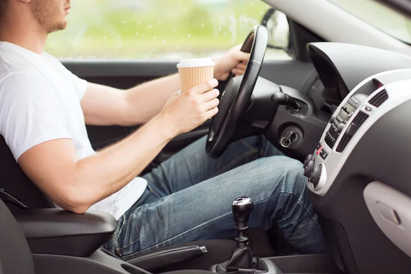 Uomo che beve caffè mentre guida l'auto — Foto Stock