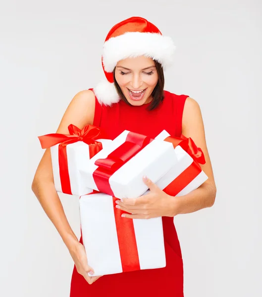 Femme surprise dans le chapeau de Père Noël avec de nombreuses boîtes-cadeaux — Photo