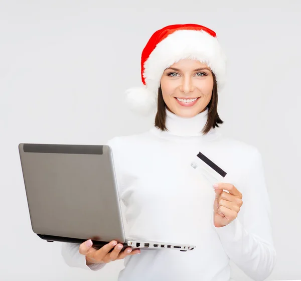 Vrouw in kerstmuts met een laptop en credit card — Stockfoto