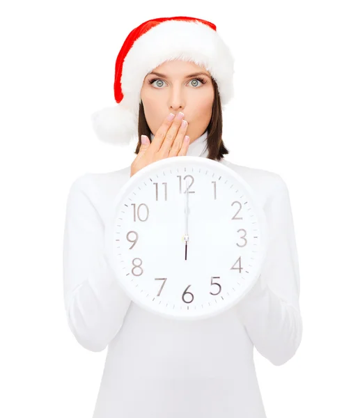 Frau mit Weihnachtsmann-Helfermütze und Uhr mit 12 — Stockfoto