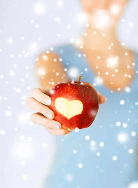 Mujer mano sosteniendo manzana roja con forma de corazón —  Fotos de Stock