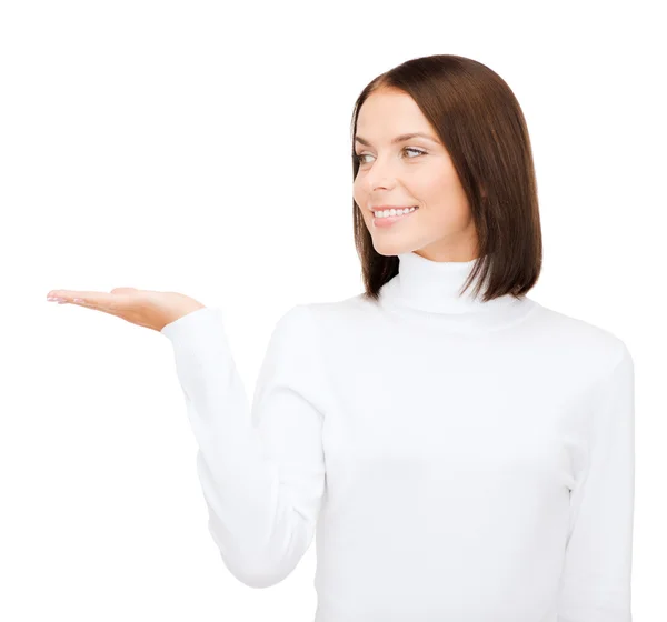 Frau im weißen Pullover mit etwas auf der Handfläche — Stockfoto