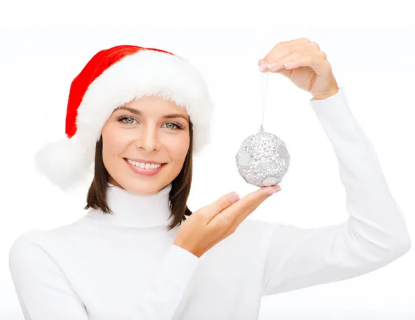 Frau mit Weihnachtsmann-Helfermütze mit Weihnachtskugel — Stockfoto