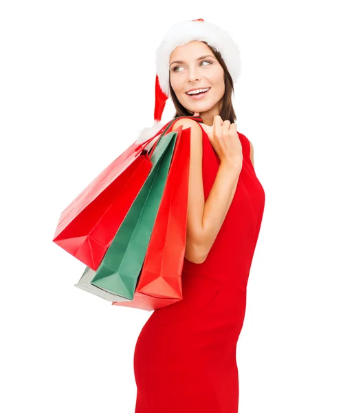 Kvinna i röd klänning med shoppingväskor — Stockfoto