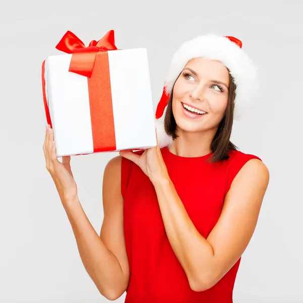 Mujer sonriente en sombrero de ayudante de santa con caja de regalo — Foto de Stock