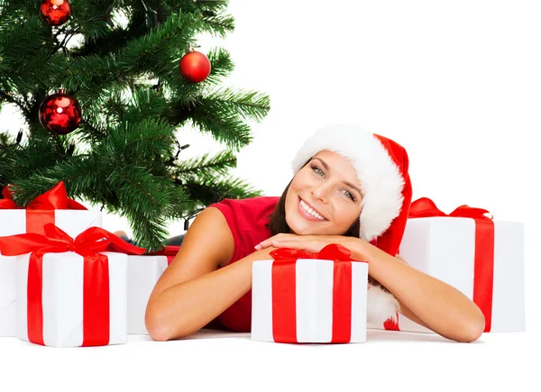 Mujer sonriente en sombrero de ayudante de santa con cajas de regalo — Foto de Stock