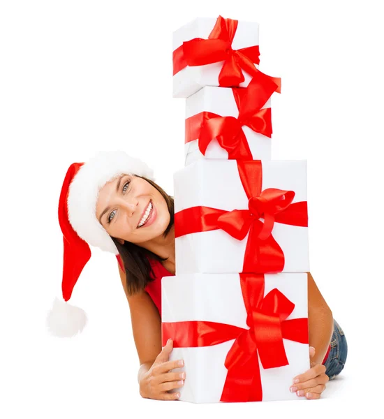 Donna sorridente in cappello Babbo Natale helper con scatole regalo — Foto Stock