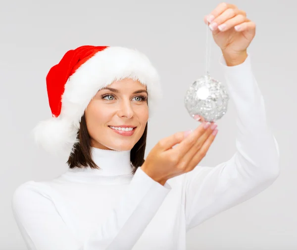 Mujer en sombrero de ayudante de santa con bola de Navidad — Foto de Stock