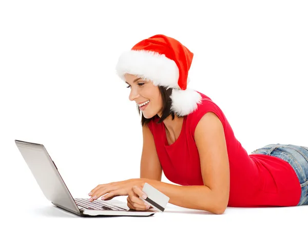 Vrouw in kerstmuts met een laptop en credit card — Stockfoto