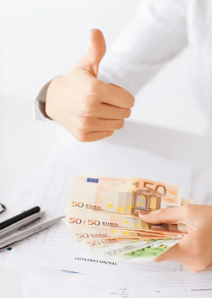 Mujer manos con dinero en efectivo en euros y pulgares hacia arriba —  Fotos de Stock