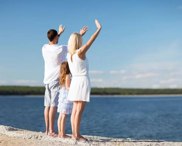 Familia feliz en la orilla del mar — Foto de Stock