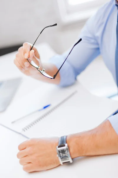 Geschäftsmann mit Brille schreibt in Notizbuch — Stockfoto