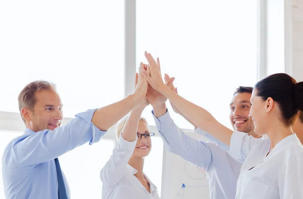 Equipe de negócios feliz dando alta cinco no escritório — Fotografia de Stock