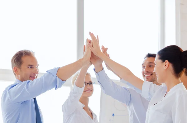 Feliz equipo de negocios dando cinco en la oficina — Foto de Stock