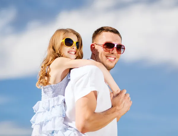 Šťastný otec a dítě v sluneční brýle nad modrá obloha — Stock fotografie