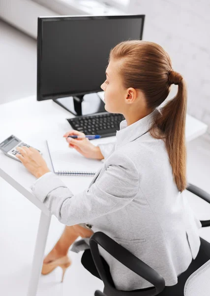 Businesswoman with notebook and calculator — Stock Photo, Image