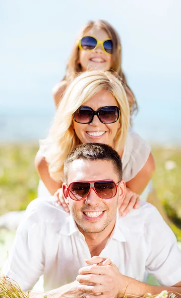 Šťastná rodina s modré oblohy a zelené trávy — Stock fotografie