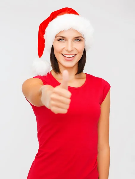 Mujer en sombrero ayudante de santa mostrando los pulgares hacia arriba —  Fotos de Stock