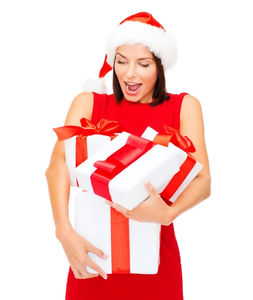 Mujer en sombrero de ayudante de santa con muchas cajas de regalo — Foto de Stock