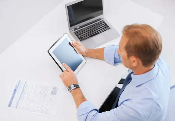 Zakenman met tablet pc en documenten in office — Stockfoto