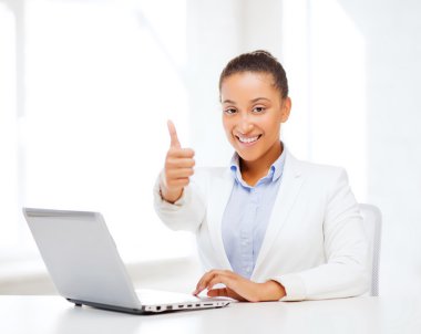 Businesswoman with laptop showing thumbs up clipart