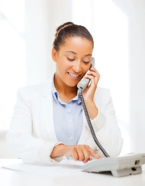 Empresária africana com telefone no escritório — Fotografia de Stock