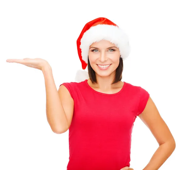 Vrouw in helper kerstmuts met iets op palm — Stockfoto