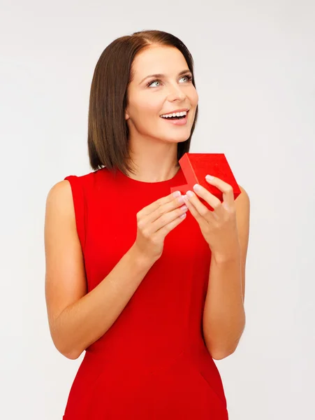 Surprised woman in red dress with gift box Stock Image