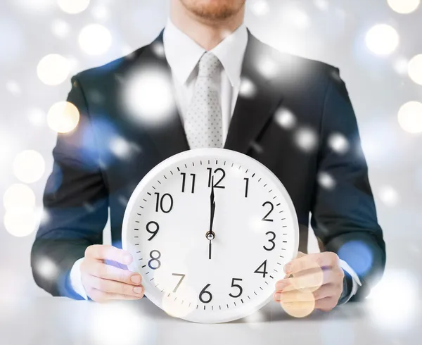 Man holding wall clock showing 12 — Stock Photo, Image