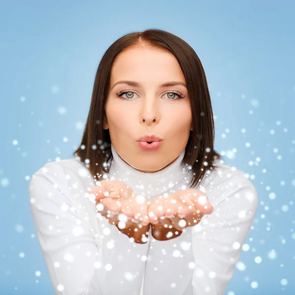 Happy woman in white sweater blowing on palms — Stock Photo, Image