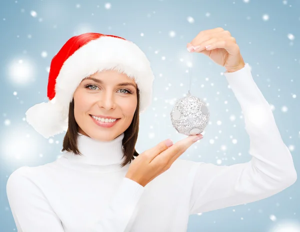 Mujer en sombrero de ayudante de santa con bola de Navidad — Foto de Stock