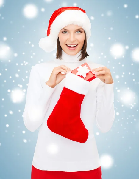 Donna in cappello da Babbo Natale con confezione regalo e calza — Foto Stock