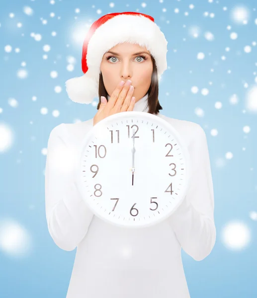 Mujer en sombrero de ayudante de santa con reloj que muestra 12 — Foto de Stock