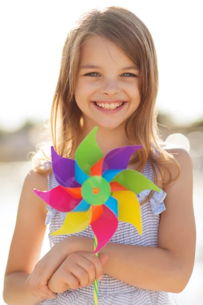 Menina feliz com brinquedo pinwheel colorido — Fotografia de Stock