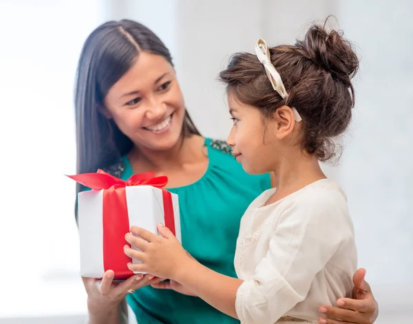 Счастливая мать и девочка с подарочной коробкой — стоковое фото