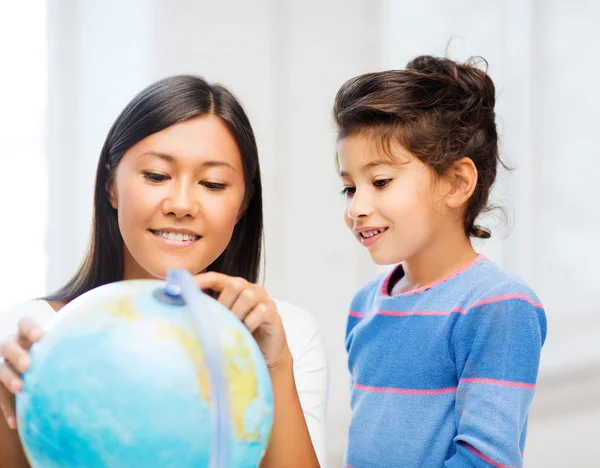 Mother and daughter with globe — Stock Photo, Image