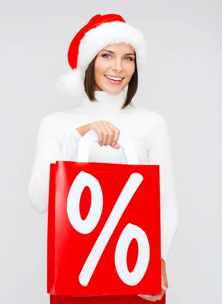 Mujer en sombrero de ayudante de santa con bolsas de compras —  Fotos de Stock