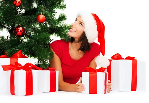 Lachende vrouw in helper kerstmuts met een geschenkdozen — Stockfoto
