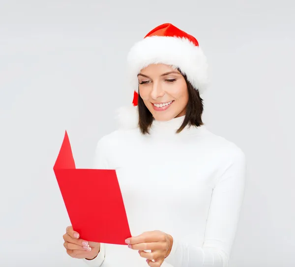 Mujer en sombrero de ayudante de santa con postal roja en blanco —  Fotos de Stock