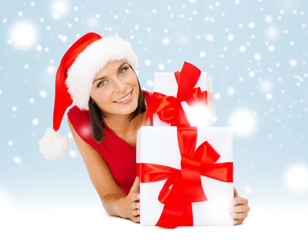 Smiling woman in santa helper hat with gift boxes Stock Picture