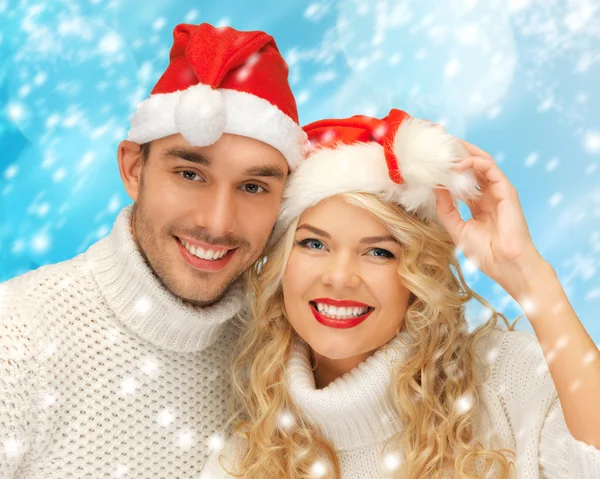 Family couple in sweaters and santa's hats — Stock Photo, Image