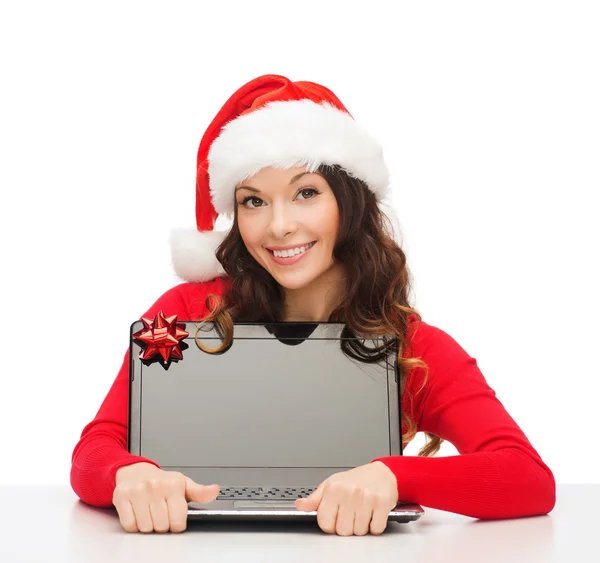 Vrouw in helper kerstmuts met een laptopcomputer — Stockfoto