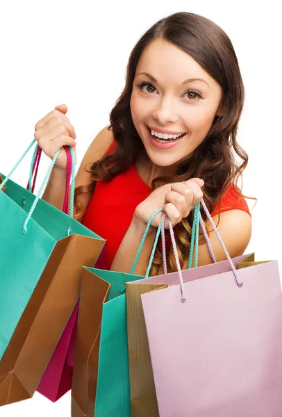 Mulher em vestido vermelho com sacos de compras — Fotografia de Stock