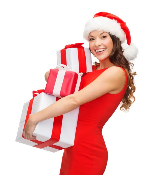 Жінка в капелюсі Санта помічника з багатьма подарунковими коробками — стокове фото